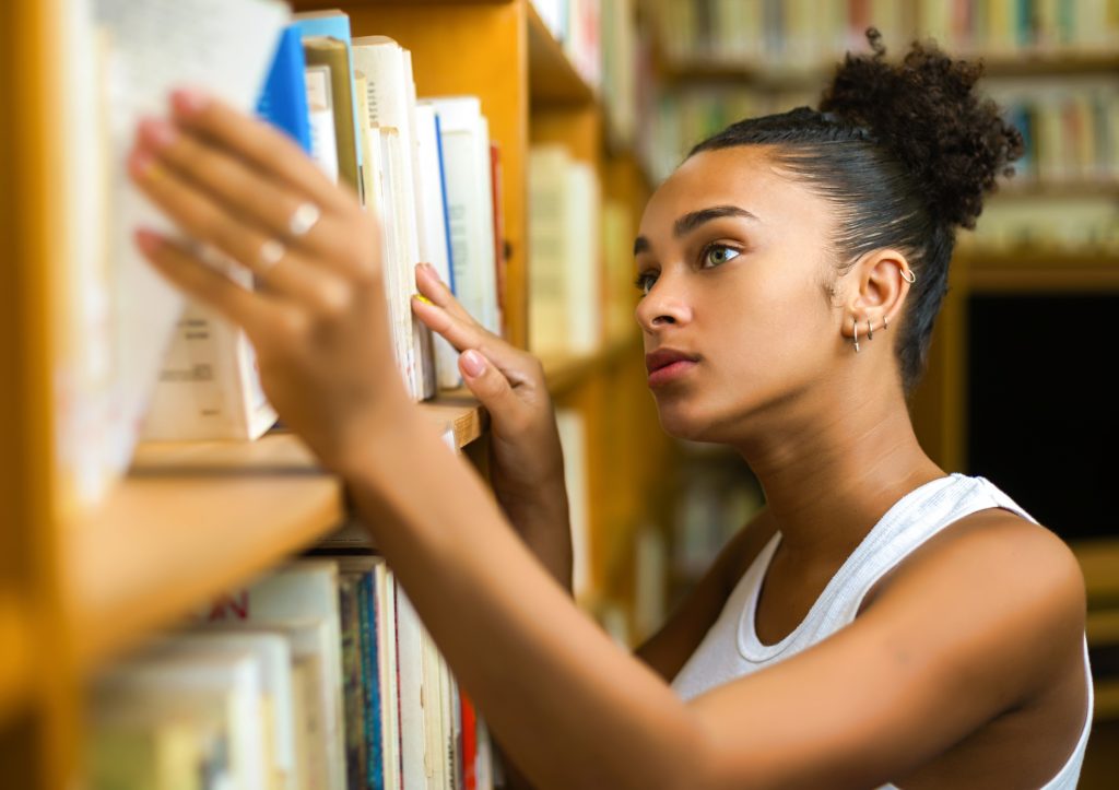 図書館で本を探す女性