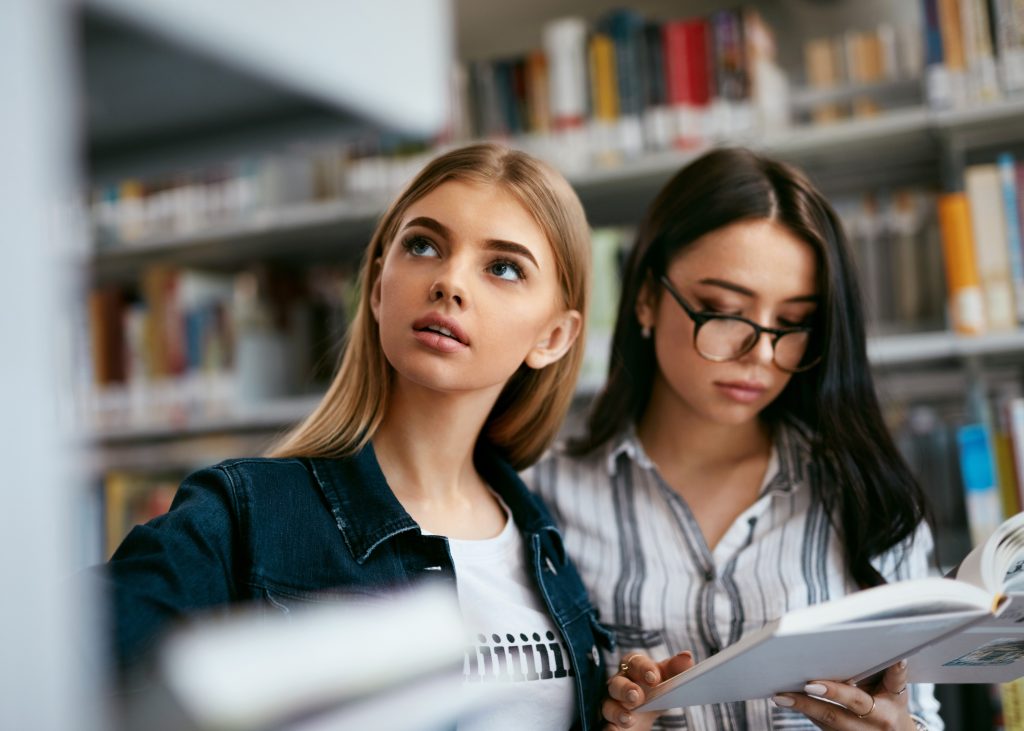 図書館で探しものをする女学生